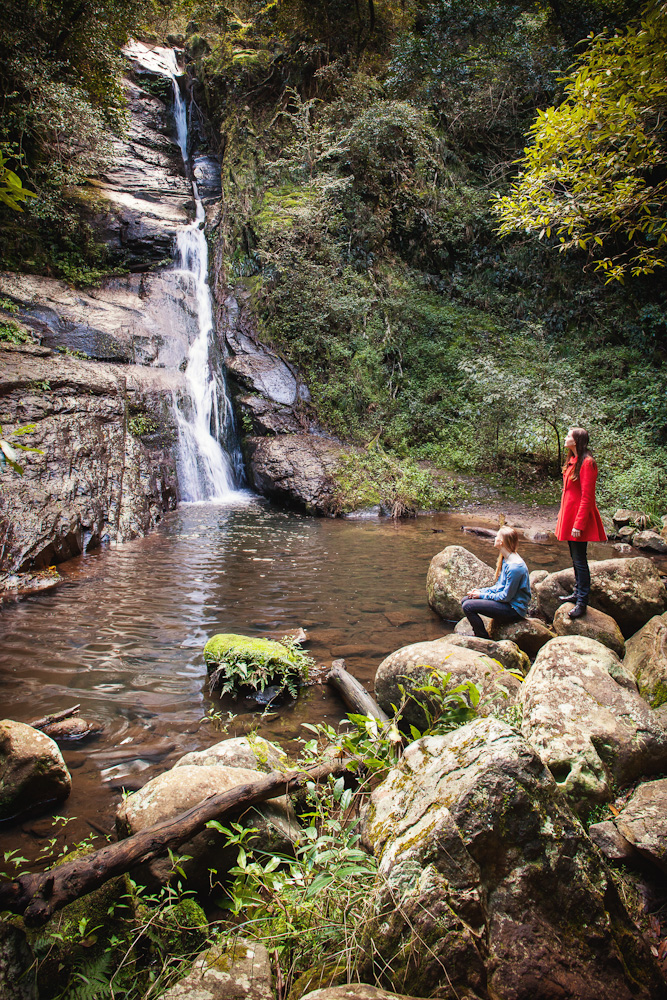 Sitting on the rocks looking at a waterfall at Macquarie Pass National Park
