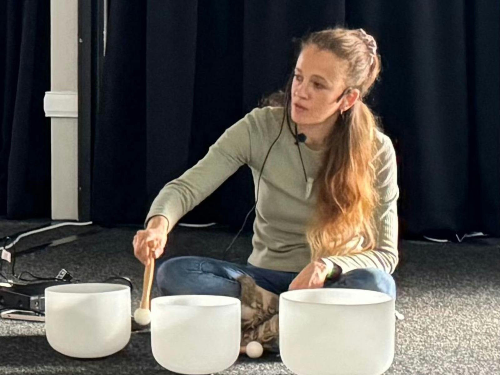 Lady playing crystal sound bowls