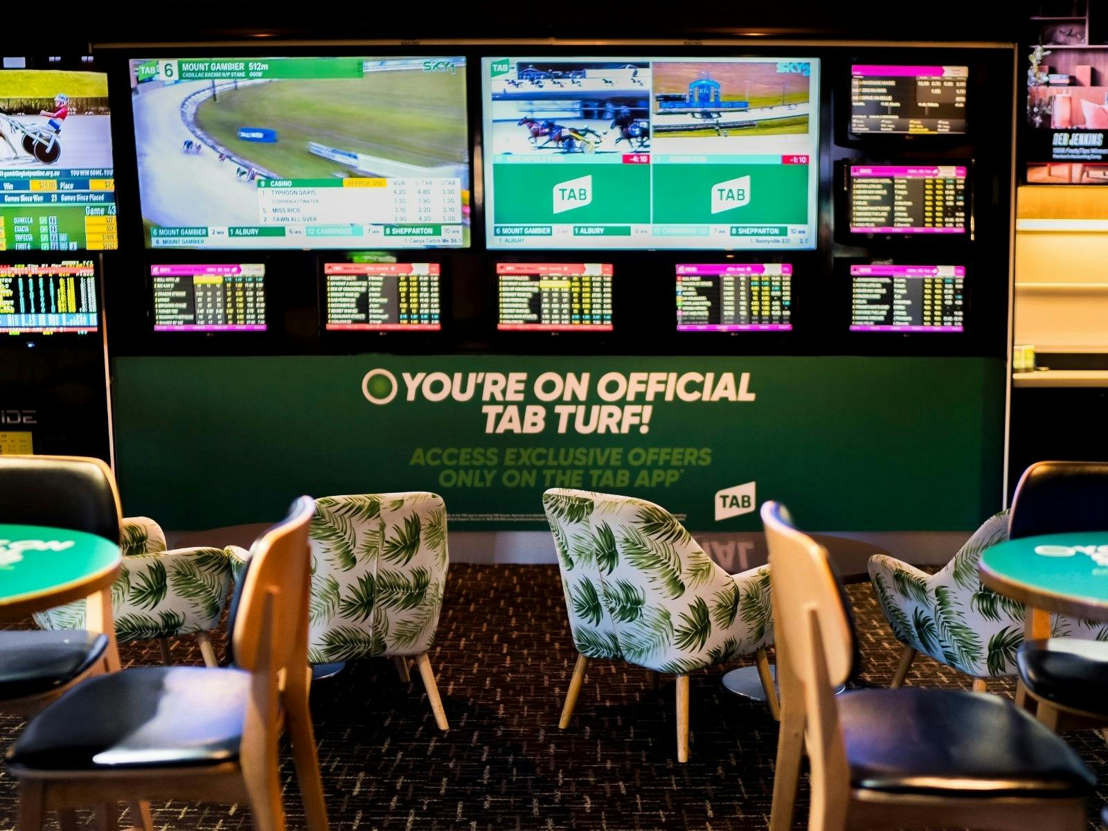 Interior of Warilla Hotel Sports Bar with lounge chairs, tables and tv wall
