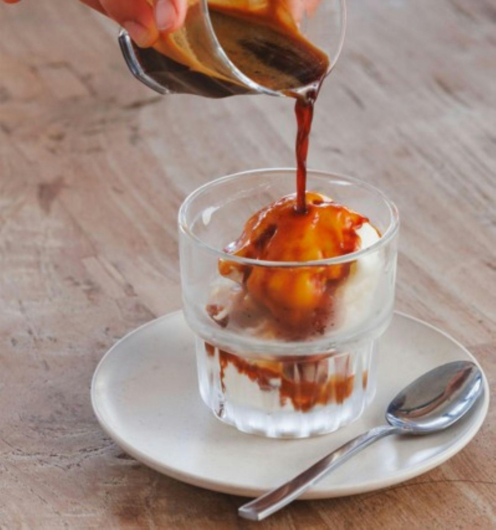 Fresh brewed coffee pouring over icecream in glass