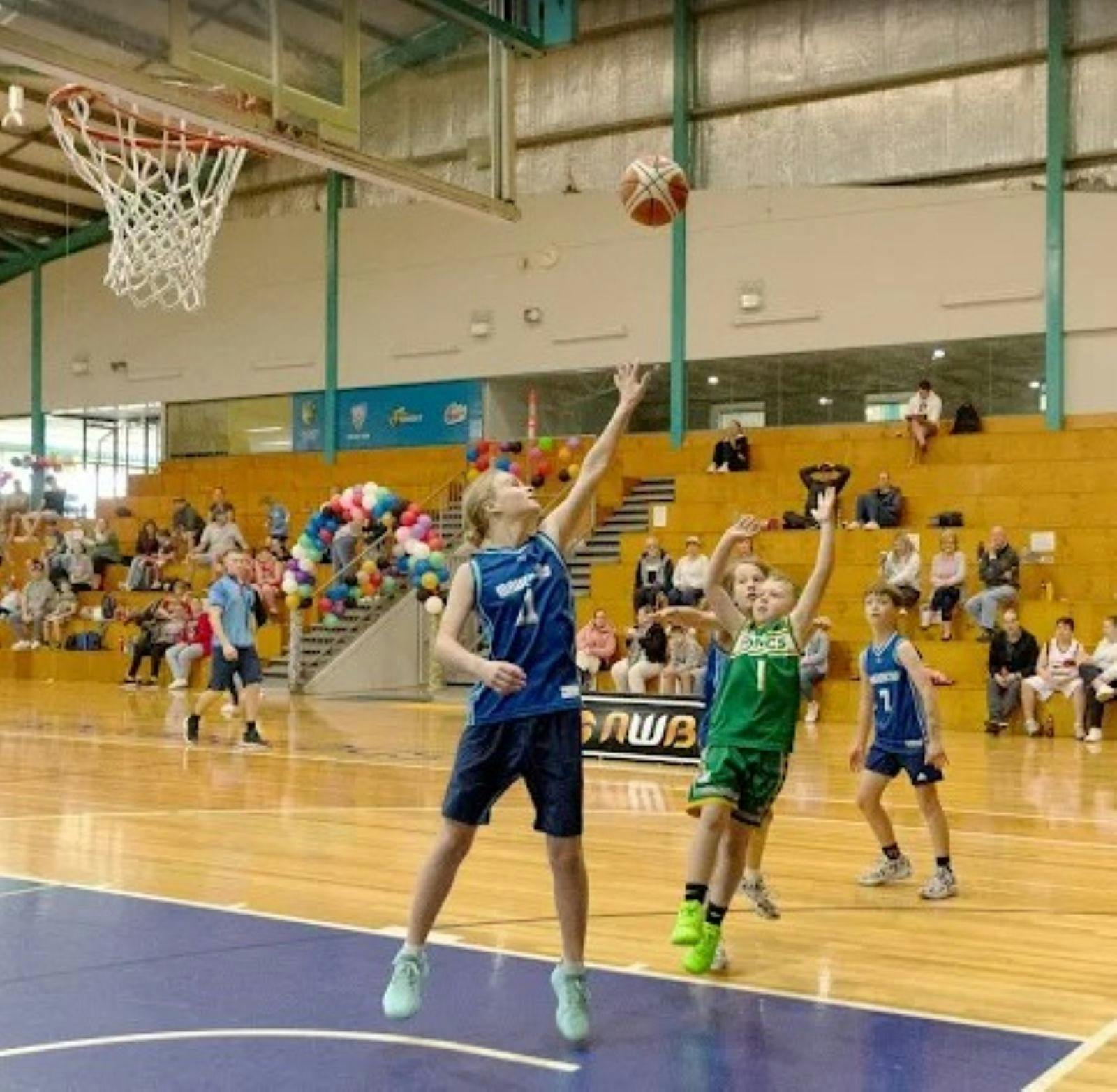 Kids playing basketball in stadium