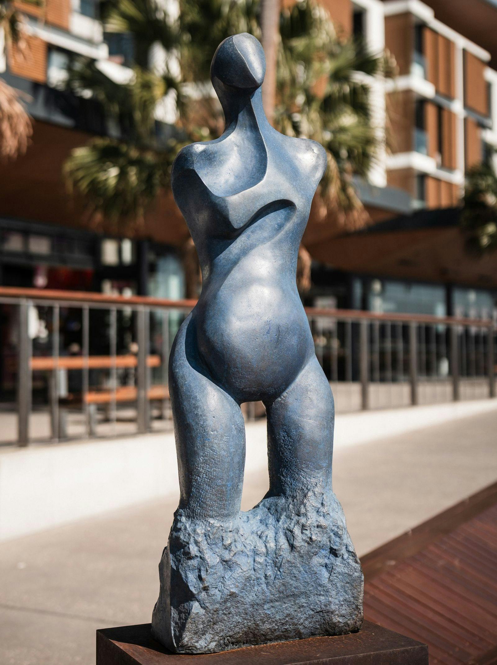 Sculpture of a lady appearing to be made out of a grey metal