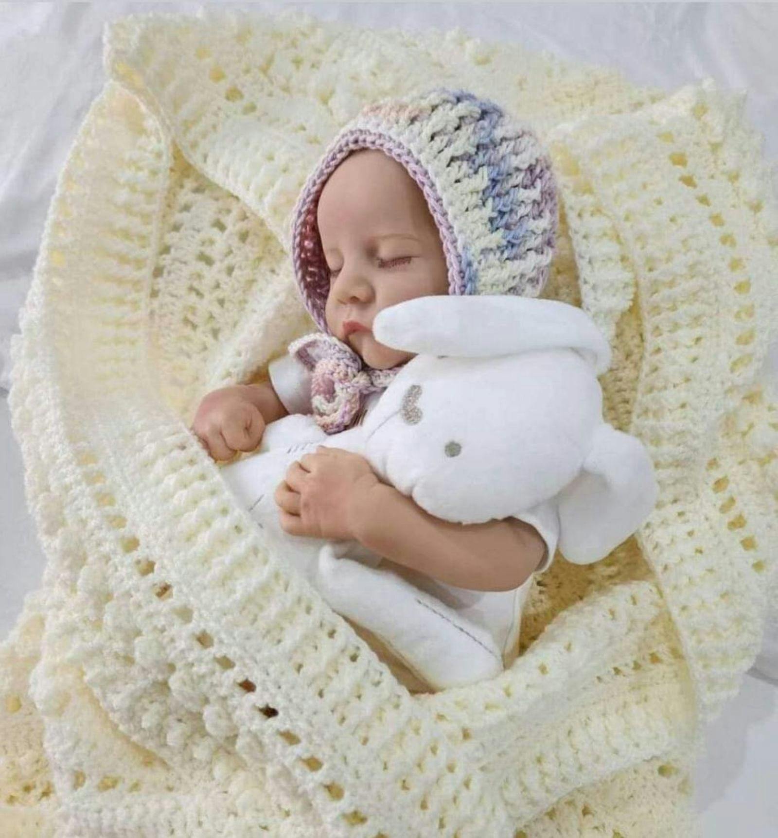 Baby in crochet blanket with a white rabit & a crochet bonnet