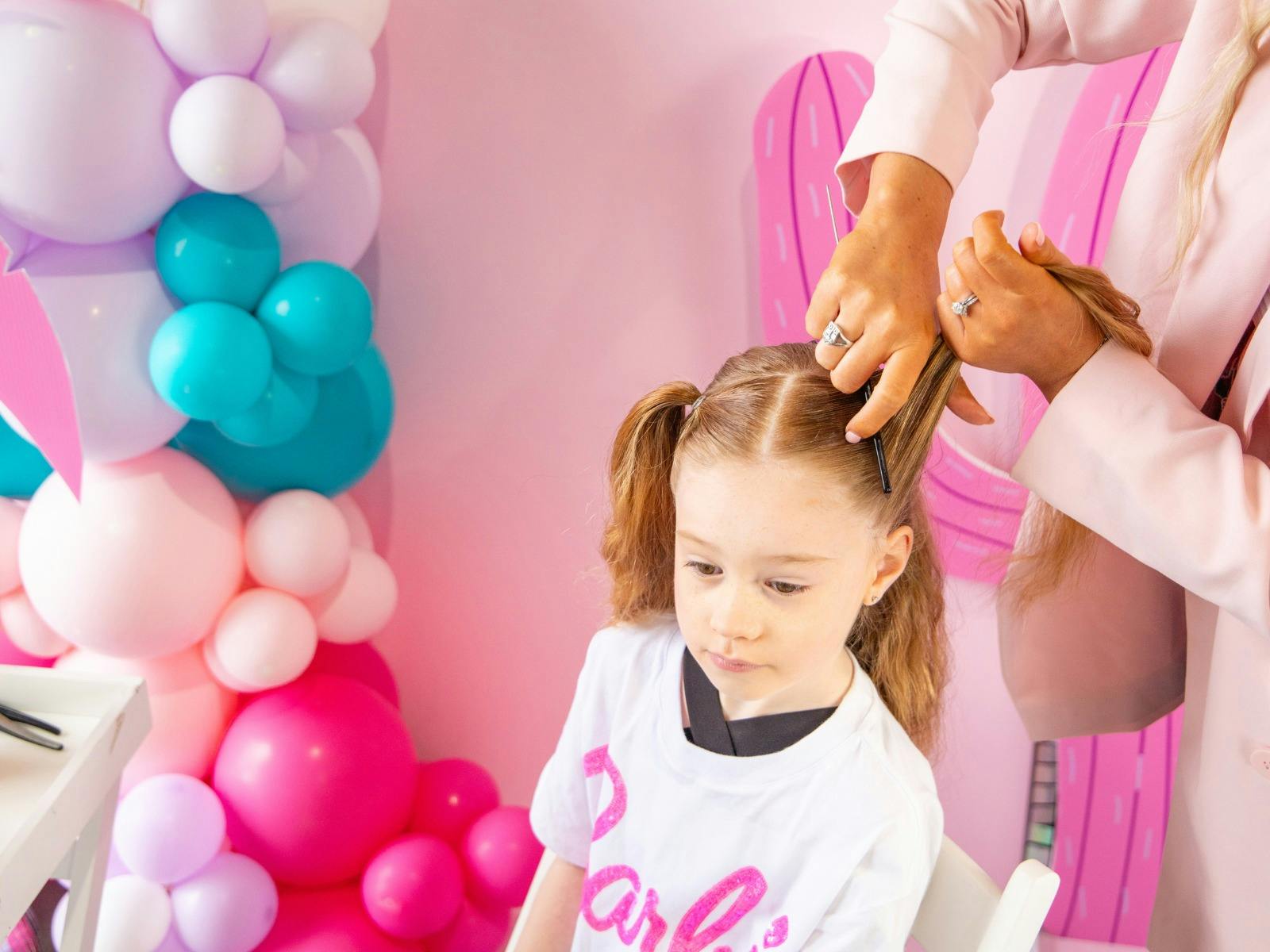 Girl getting her hair braided at party