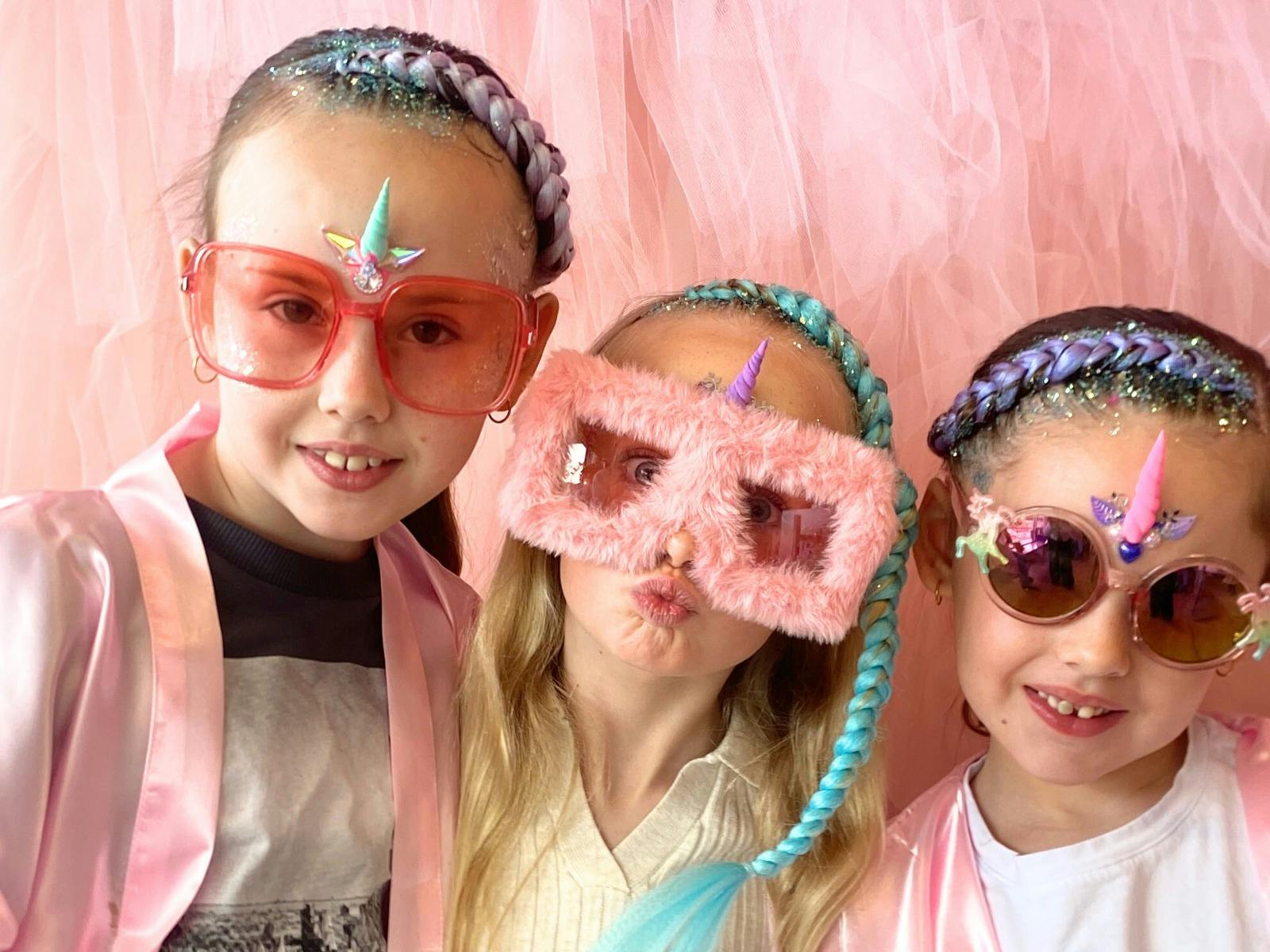 3 girls at party with funny glasses on and hair done