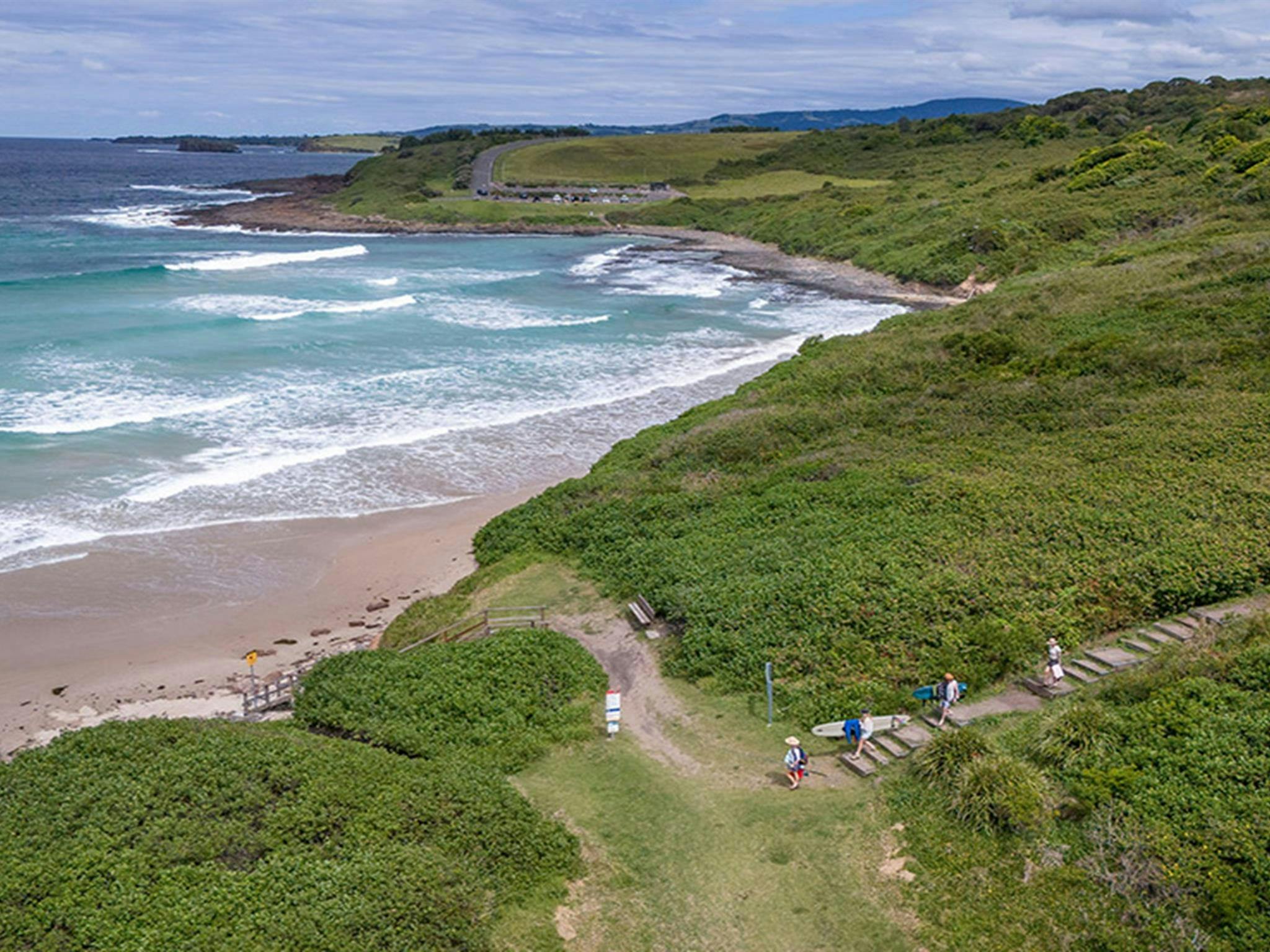 Visitors walking down the path leading to Killalea Beach – The Farm. Photo: John Spencer/DCCEEW