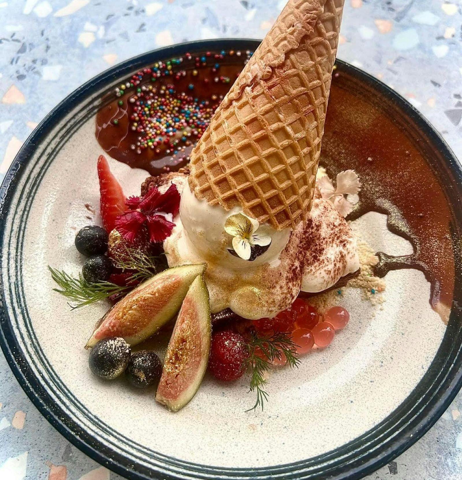 Desert with ice-cream cone and range of fruits at De Village Cafe