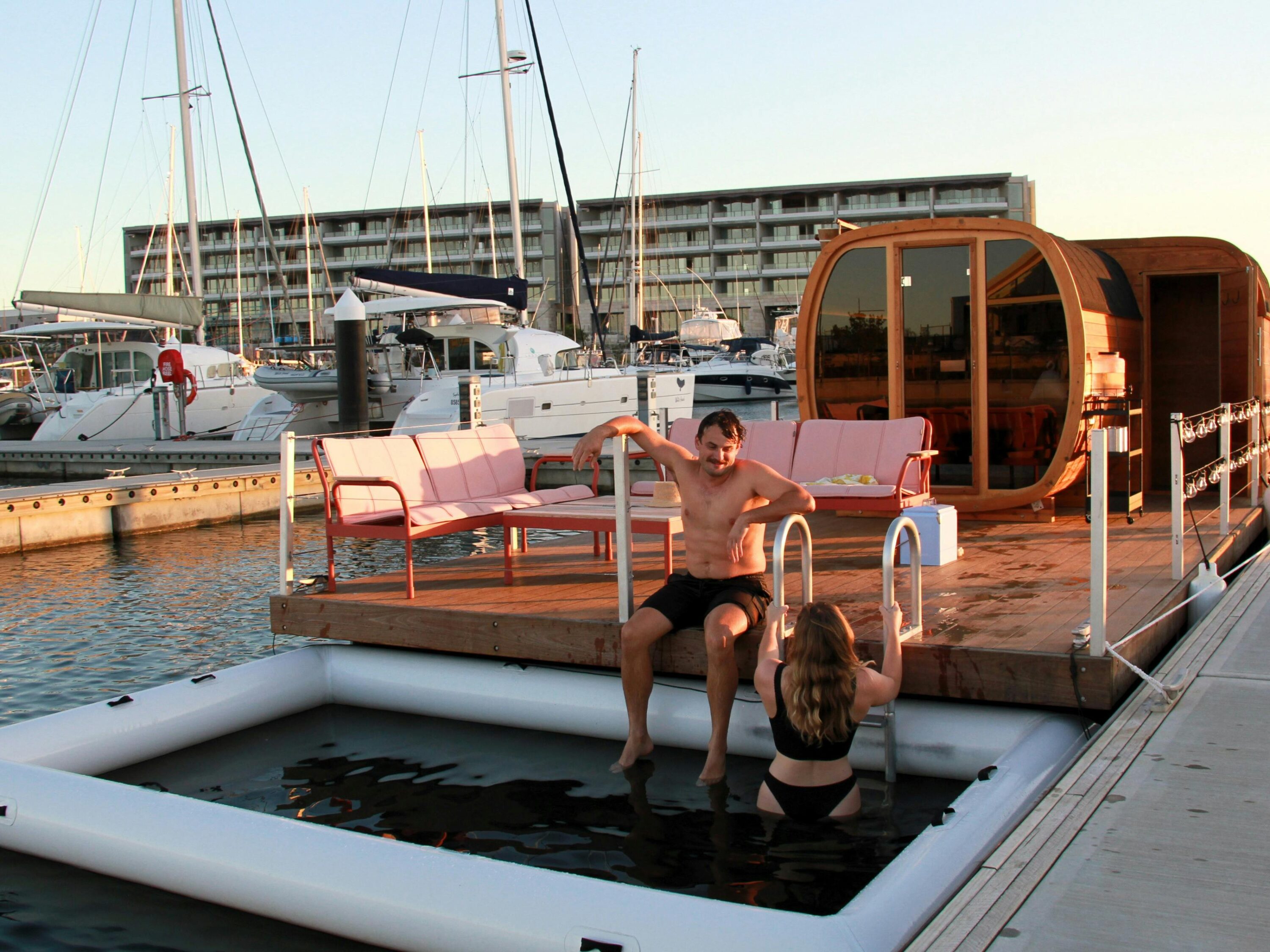 People sitting by the plung pool at Those Floating Sauna taking a dip.
