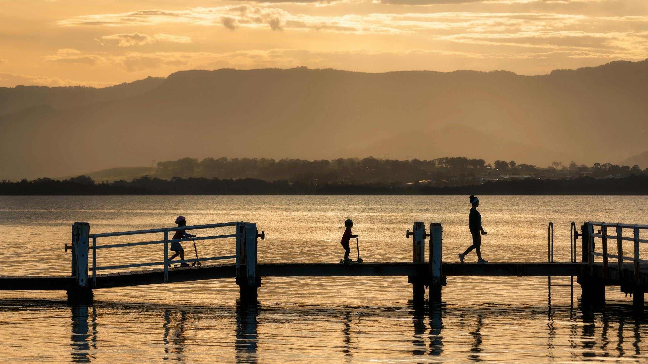 People walking on a jetty at Lake Illawarra