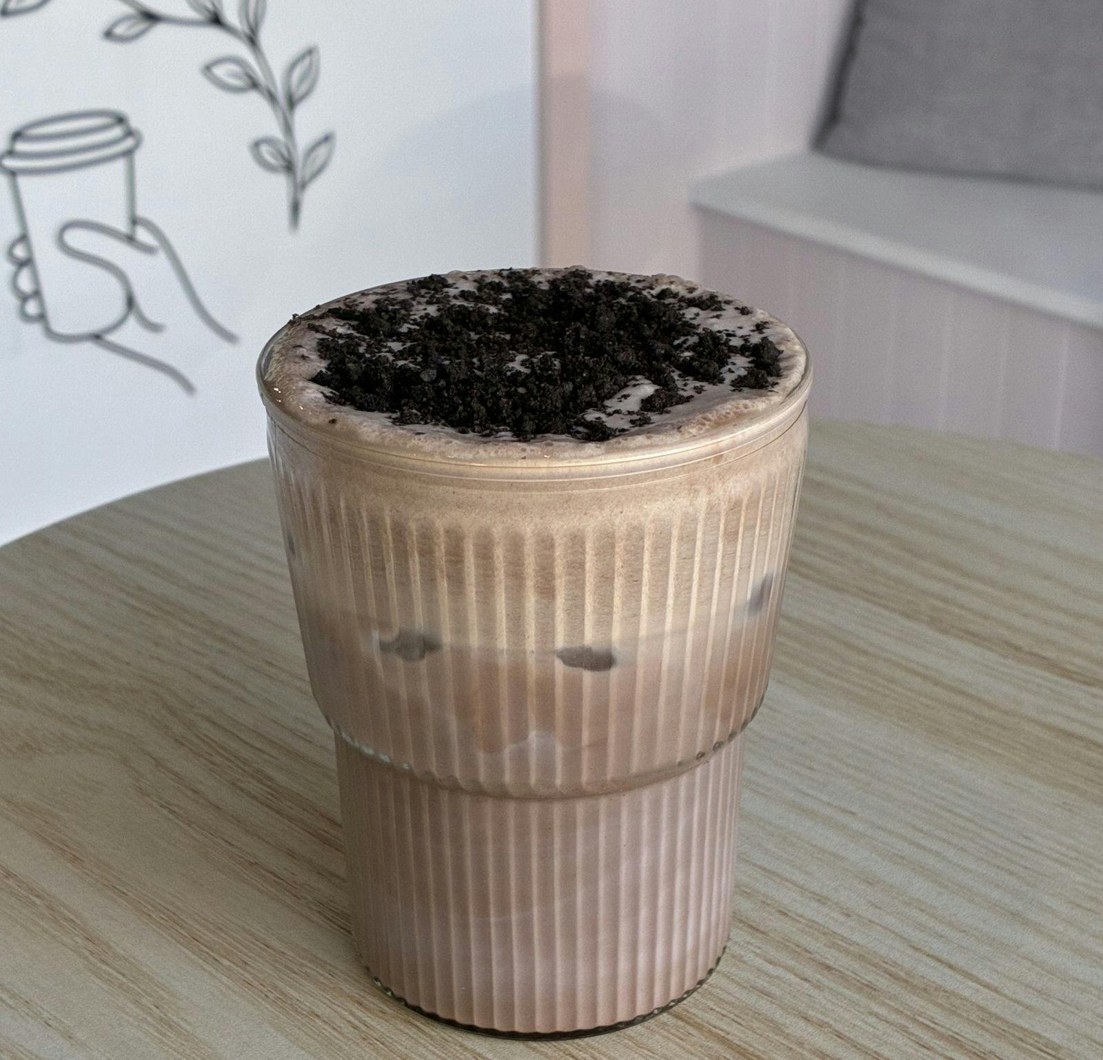 Cup filled with beverage and chocolate ontop