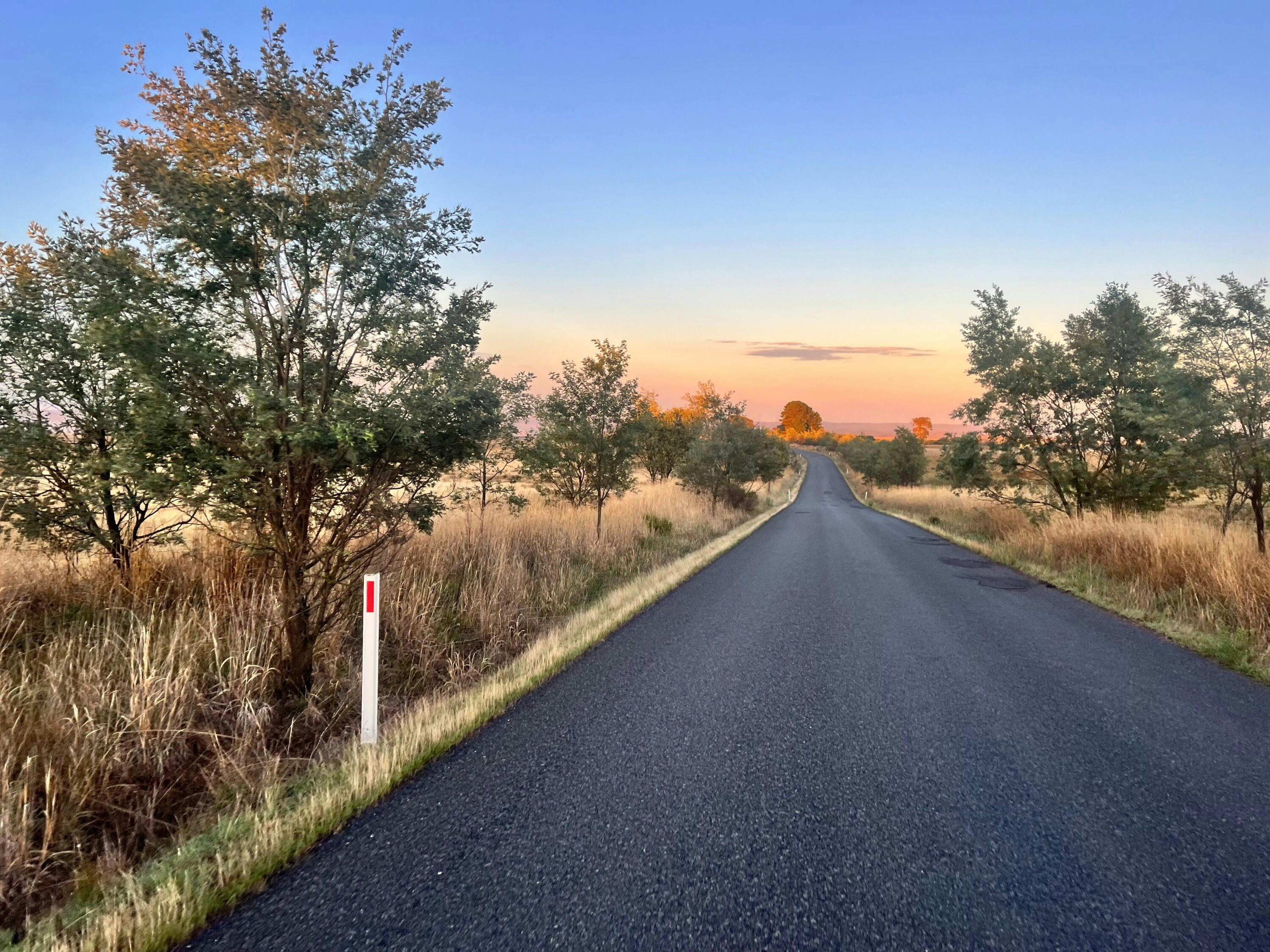 A country road at sunrise stretching off into the distance