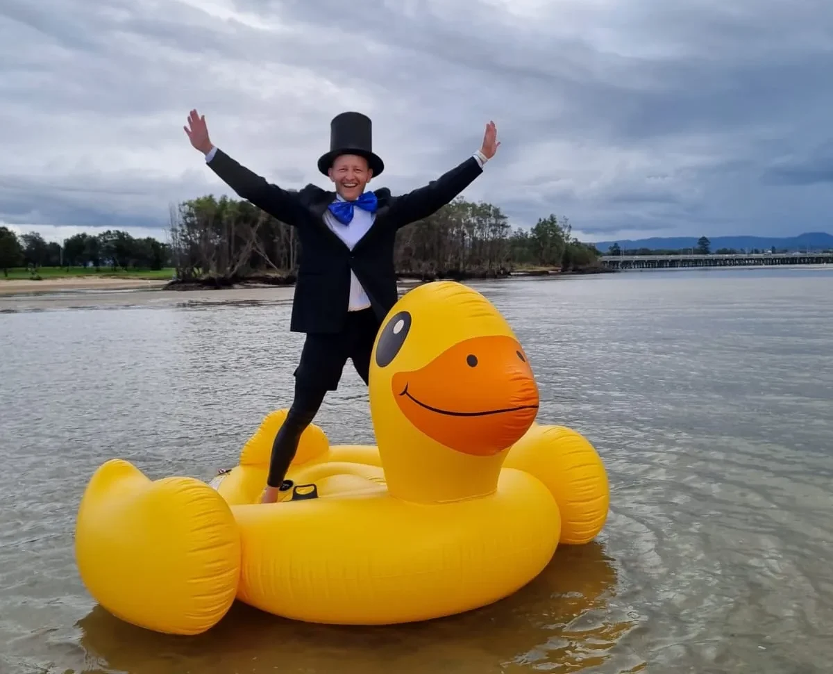 Person dressed up standing on an inflatable duck